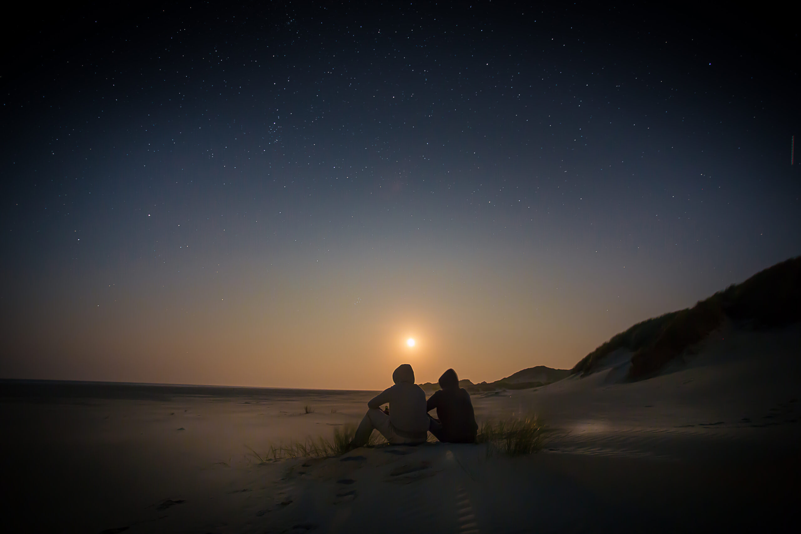 夜空星光下兩人並肩而坐剪影意象：感情合盤情感連結