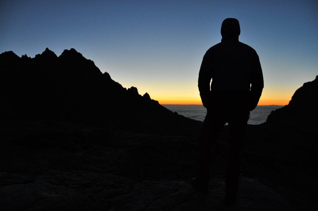 剪影獨自站立山頂眺望地平線夕陽意象:內在能量覺察